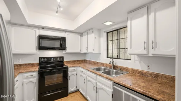 a kitchen with granite countertop a sink stainless steel appliances and cabinets