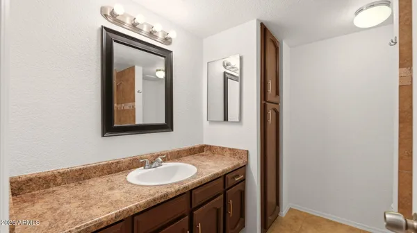a bathroom with a granite countertop sink and a mirror