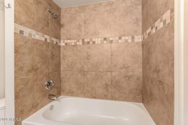 a bathroom with a white bath tub and a shower
