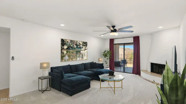 a living room with furniture a ceiling fan and a window