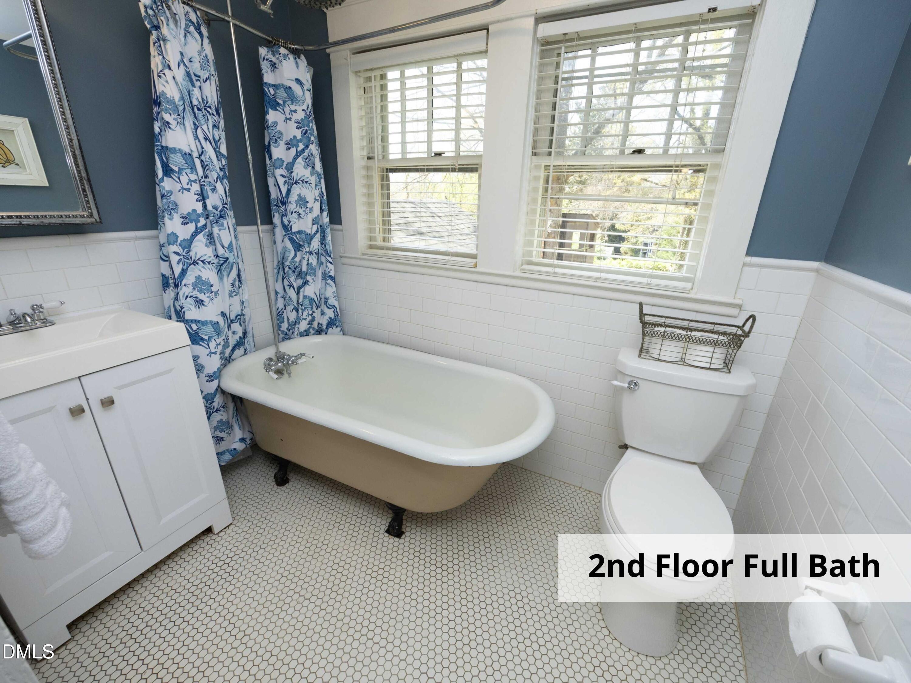 825 Onslow Street Durham, NC 27705 - Photo 43 of 71 a bathroom with a toilet a sink a mirror and a window