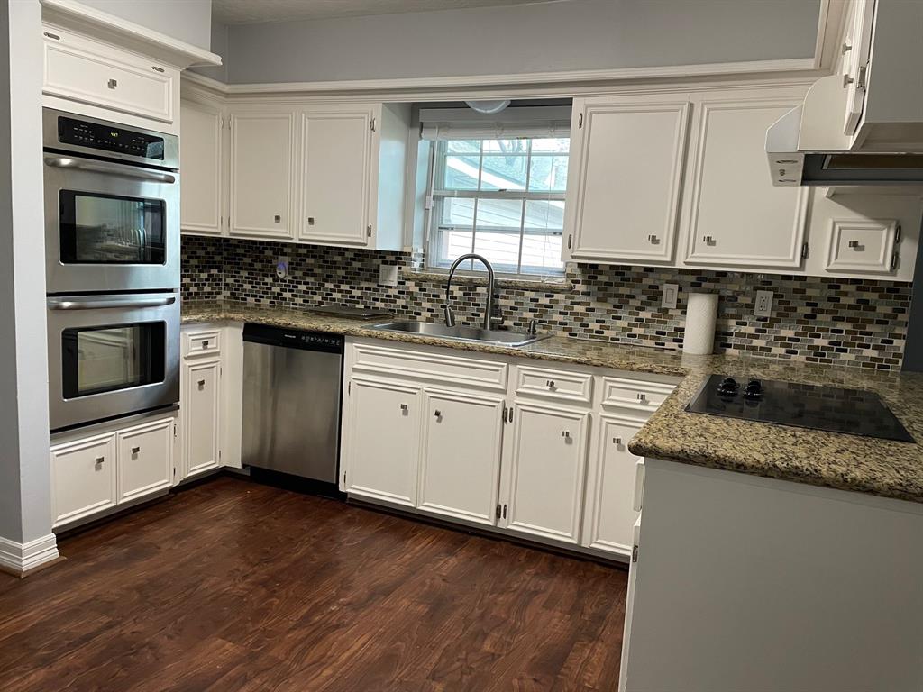a kitchen with granite countertop a sink and steel appliances