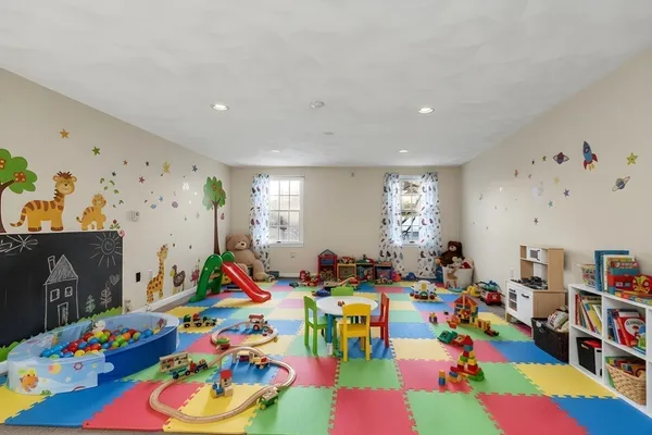 a bed room with lots of baby toys and flat tv screen