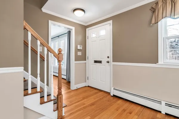a view of an entryway with wooden floor and door