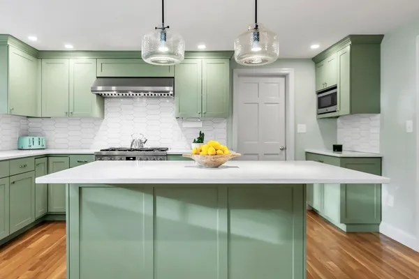 a kitchen with kitchen island stainless steel appliances a sink stove and refrigerator