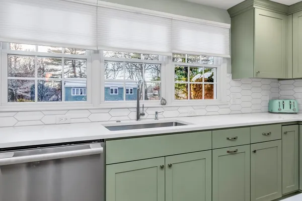 a kitchen with stainless steel appliances sink and large window