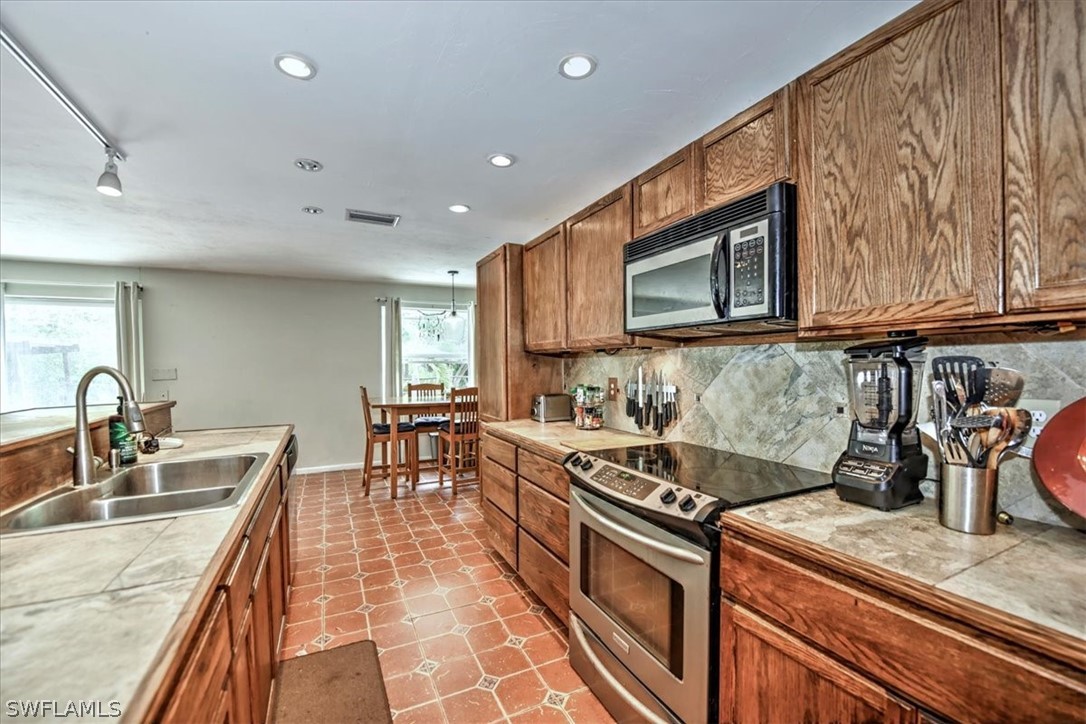 12271 Coyle Road Fort Myers, FL 33905 - Photo 13 of 33 a kitchen with stainless steel appliances granite countertop a sink stove and microwave