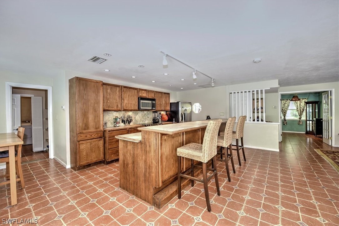 12271 Coyle Road Fort Myers, FL 33905 - Photo 14 of 33 a kitchen with stainless steel appliances granite countertop a table chairs and a refrigerator