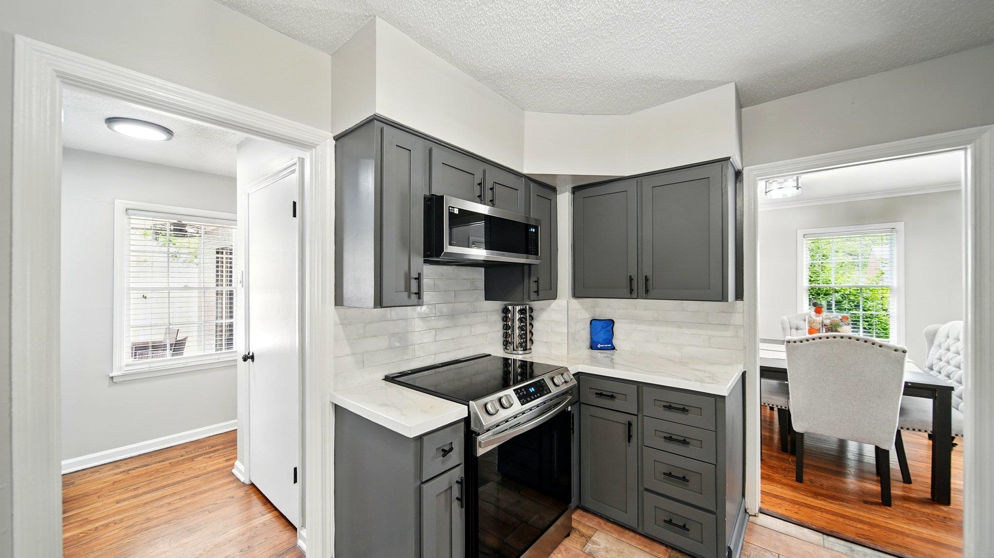 359 South Fenwick Road Memphis, TN 38111 - Photo 11 of 31 Kitchen with gray cabinetry, stainless steel appliances, light wood-style flooring, a textured ceiling, and decorative backsplash