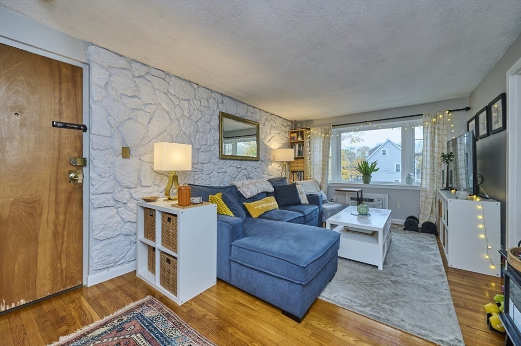 150 Wrentham Street, Unit 12 Boston, MA 02124 - Photo 1 of 12 a living room with furniture and a flat screen tv