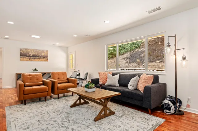 a living room with furniture a rug and a large window