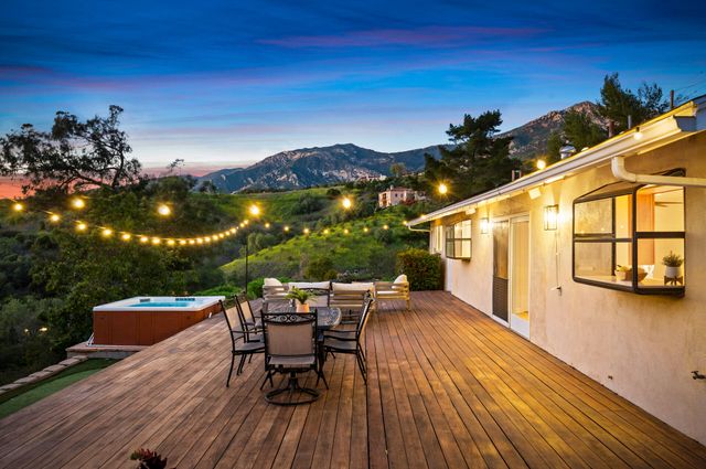 a view of a patio with a table and chairs under an umbrella with wooden floor
