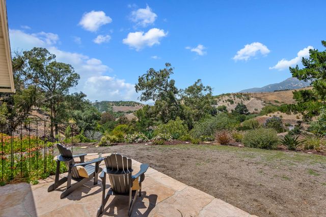 a view of a chairs and table in the backyard
