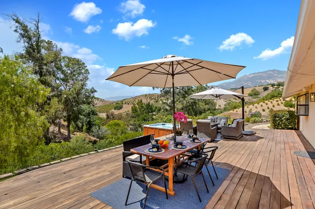 a view of a tables and chairs under an umbrella in backyard