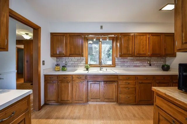 a kitchen with a sink window and cabinets