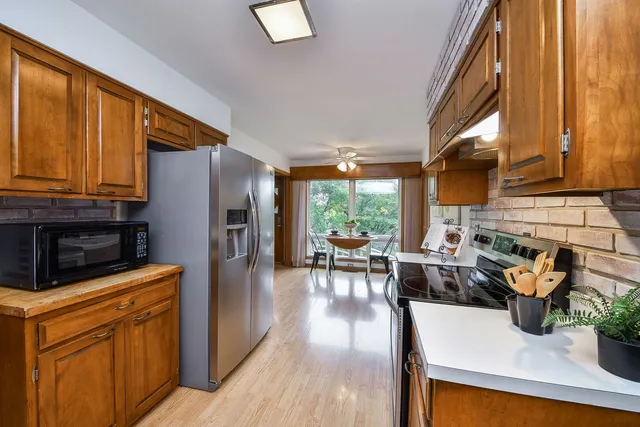 a kitchen with stainless steel appliances a refrigerator a sink a stove and white cabinets