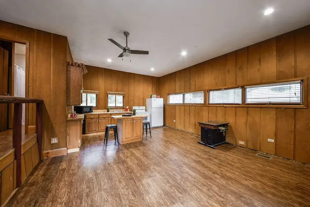 a view of a kitchen with kitchen island a counter space a sink and wooden floor
