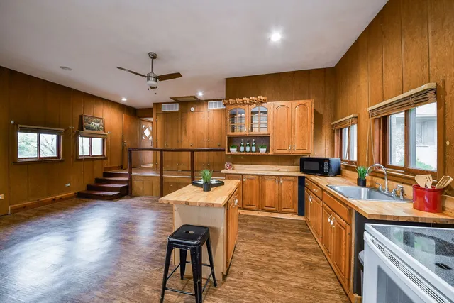 a large kitchen with lots of counter space a sink a window and stainless steel appliances