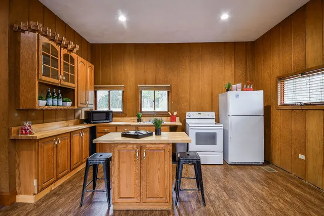 a kitchen with a refrigerator a stove and wooden floor