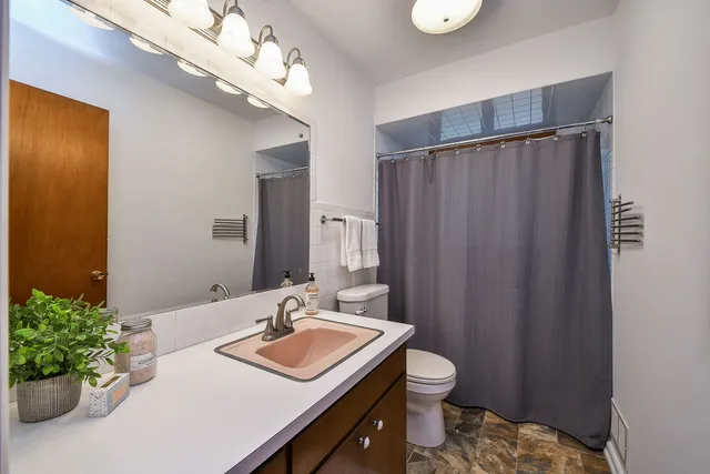 a bathroom with a granite countertop sink a toilet and a mirror