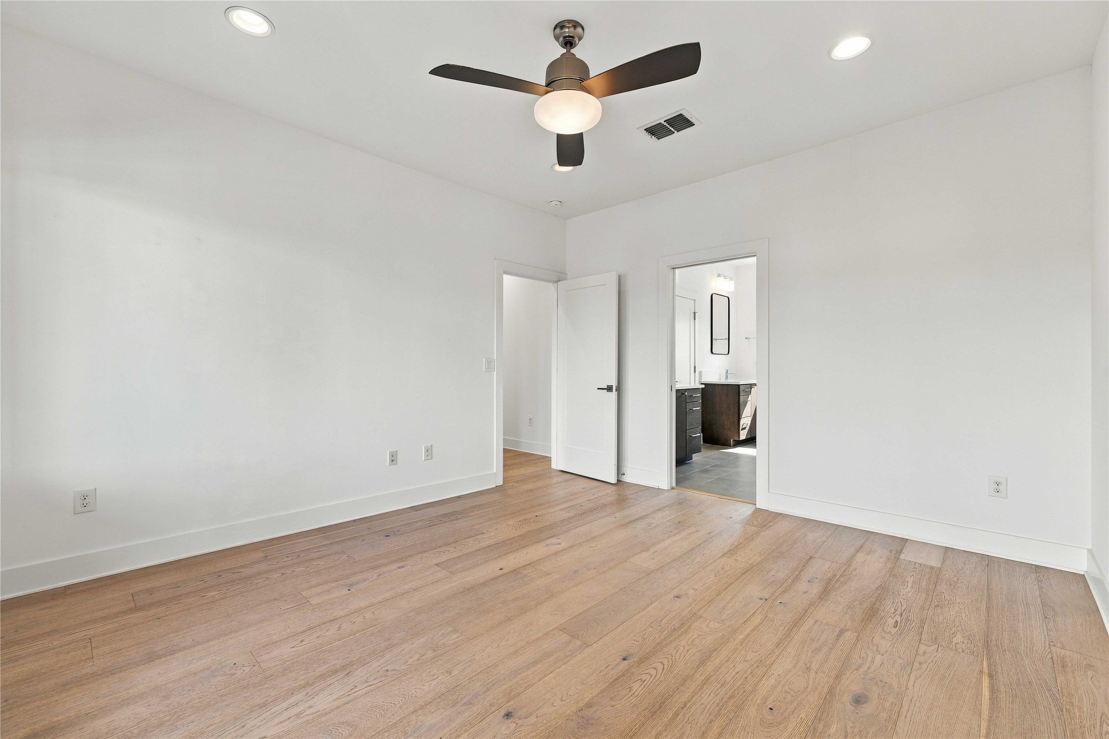 5006 Pecan Springs Road, Unit 7 Austin, TX 78723 - Photo 13 of 38 Warm hardwood floors and recessed lighting define this inviting primary suite.