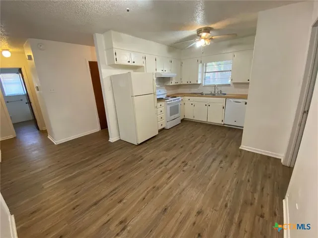 a view of a kitchen with wooden floor and electronic appliances