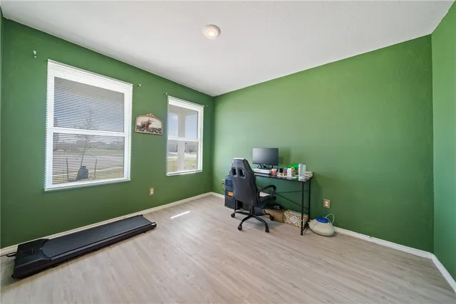 a view of a workspace with furniture and a window