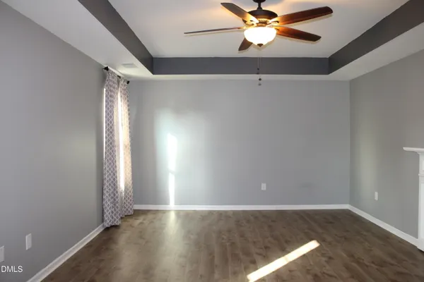 an empty room with windows and fan
