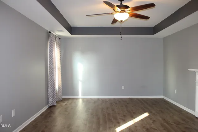 an empty room with windows and fan