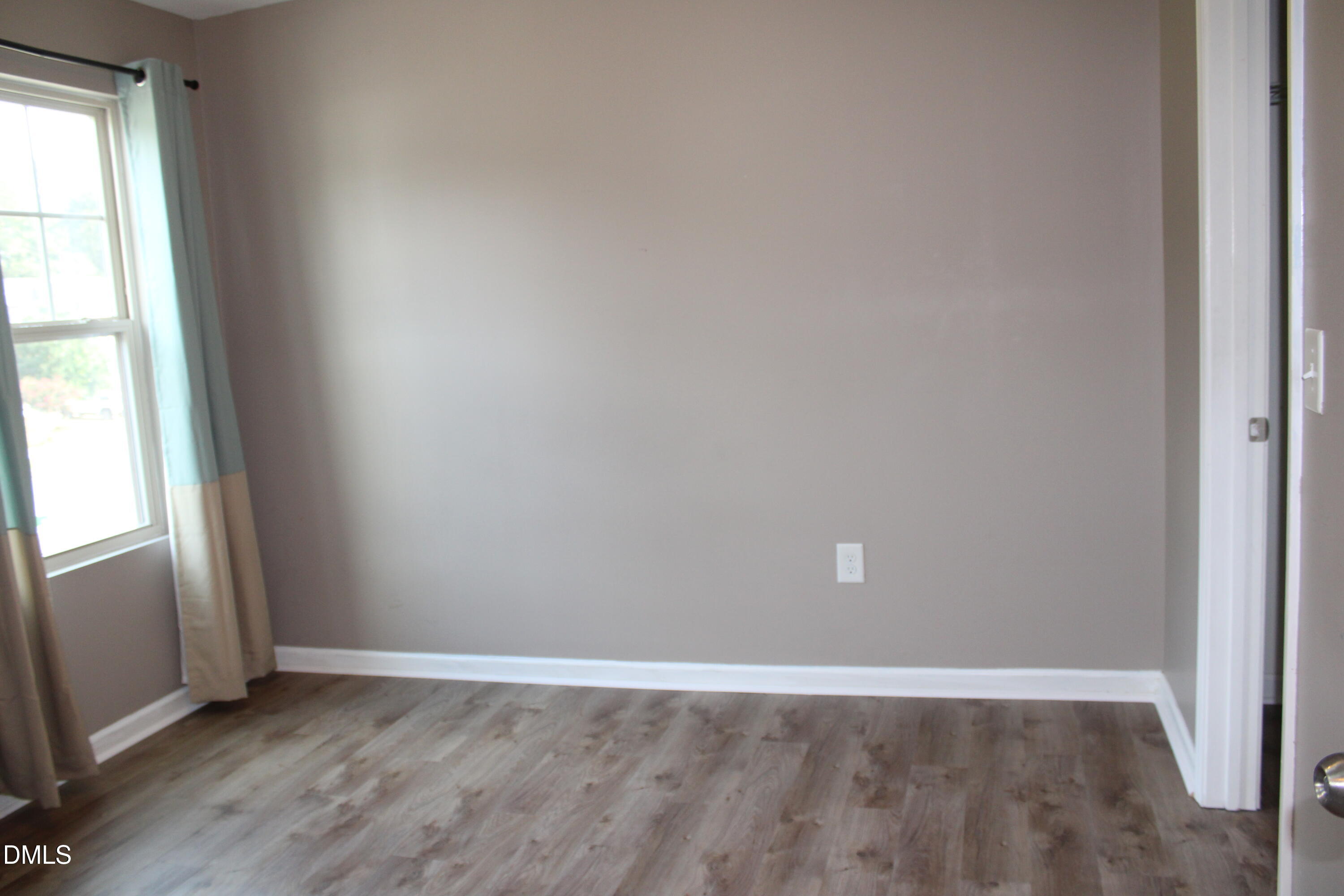 138 Lyonshall Street Fuquay-Varina, NC 27526 - Photo 20 of 24 an empty room with wooden floor and windows