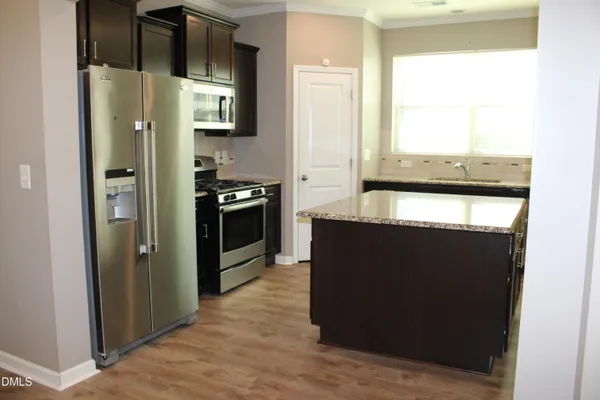 a kitchen with stainless steel appliances granite countertop a refrigerator and a stove