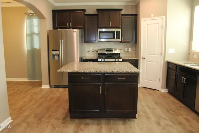 a kitchen with stainless steel appliances granite countertop a refrigerator a stove a sink and a refrigerator