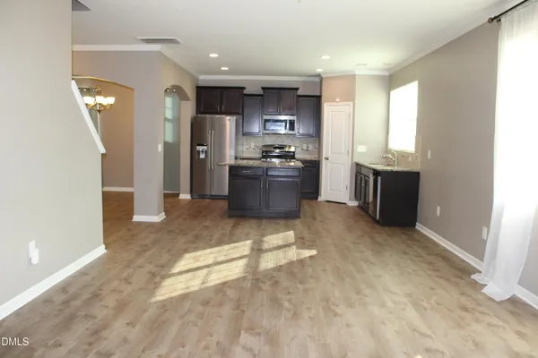 a kitchen with stainless steel appliances kitchen island granite countertop a refrigerator and a stove top oven