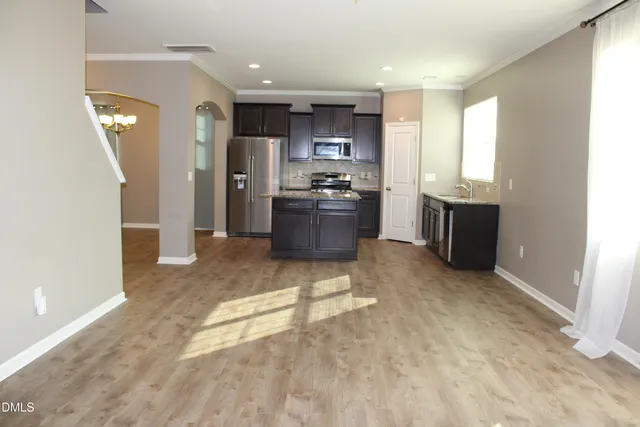 a kitchen with stainless steel appliances kitchen island granite countertop a refrigerator and a stove top oven