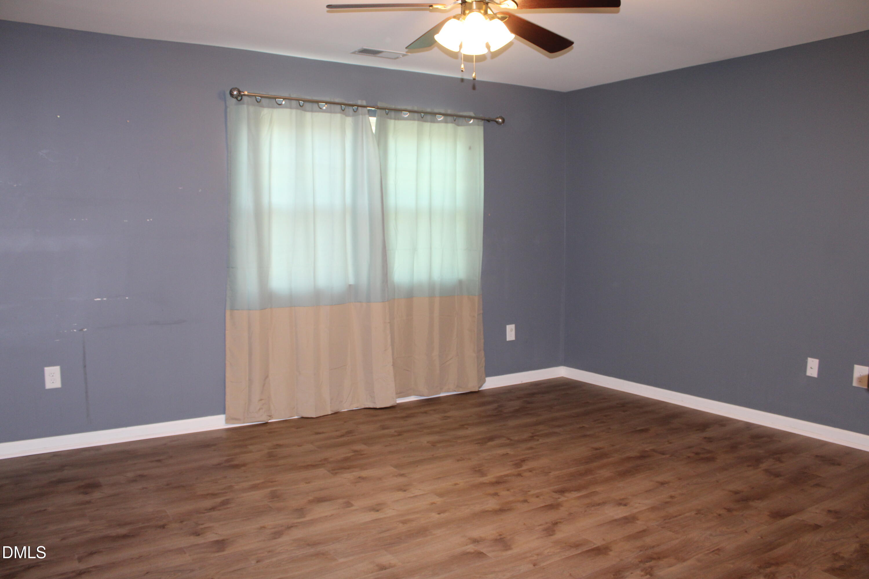 138 Lyonshall Street Fuquay-Varina, NC 27526 - Photo 10 of 24 an empty room with wooden floor and windows