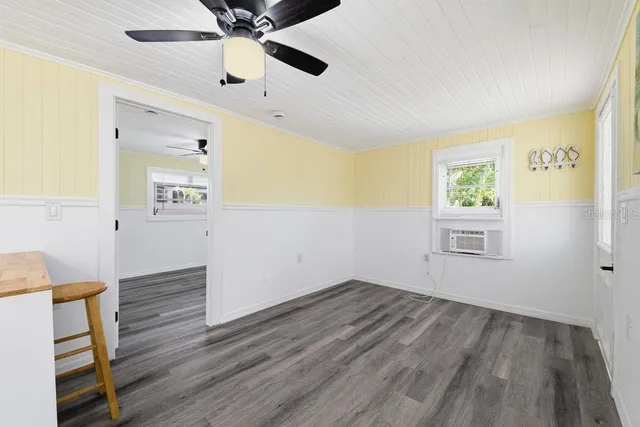 a kitchen with cabinets wooden floor and stainless steel appliances