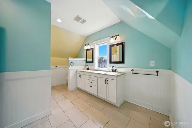 a spacious bathroom with a double vanity sink mirror and toilet