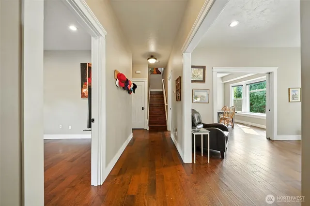 a hallway with wooden floor fireplace and windows