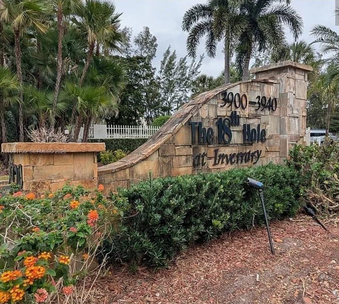 a view of a house with large trees and plants