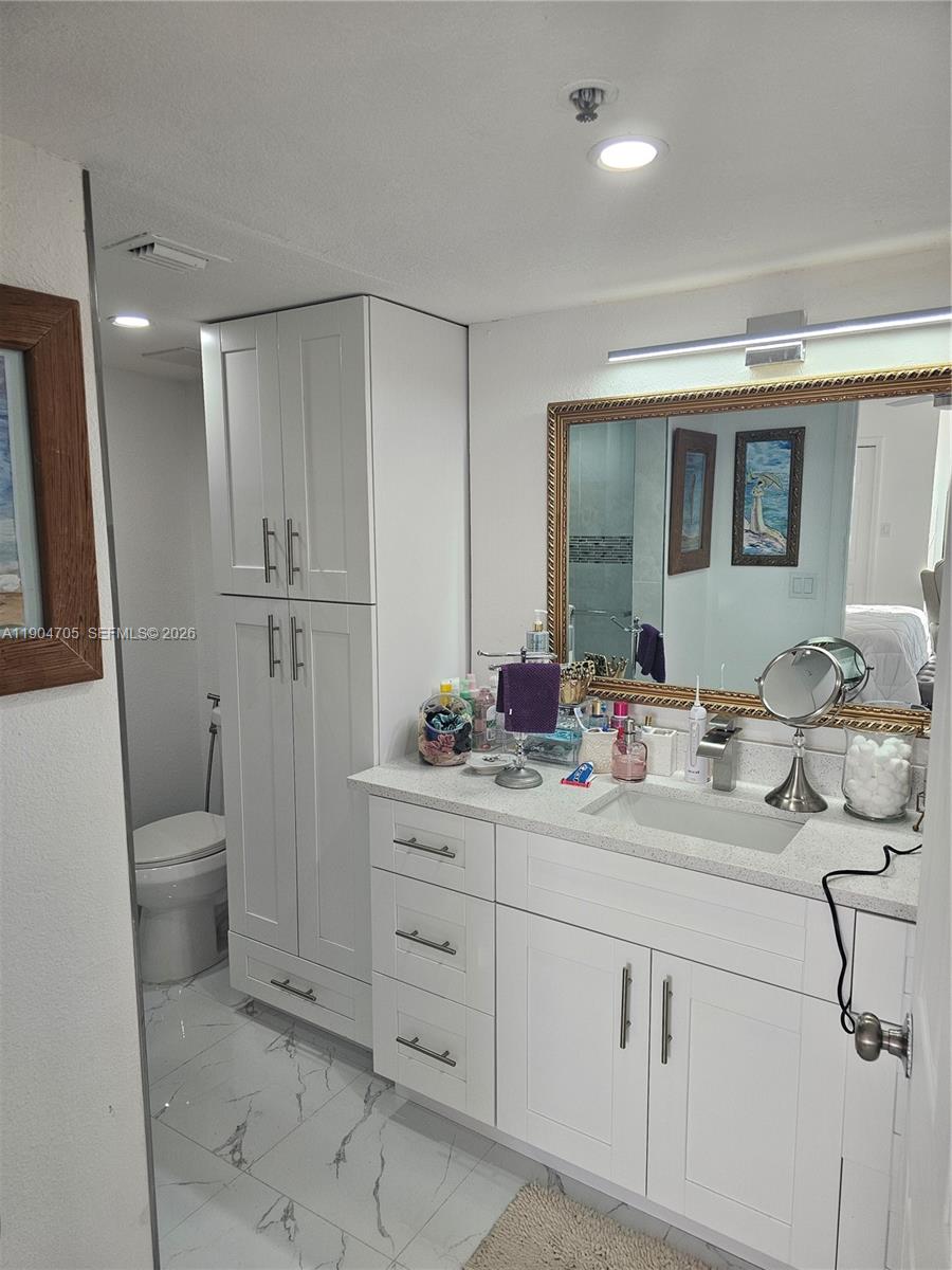 3910 Inverrary Boulevard, Unit 703B Lauderhill, FL 33319 - Photo 13 of 30 a bathroom with a toilet sink and mirror