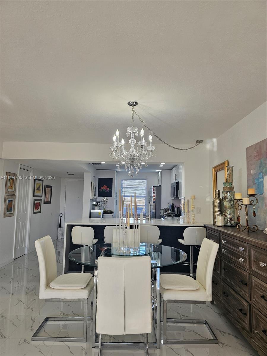 3910 Inverrary Boulevard, Unit 703B Lauderhill, FL 33319 - Photo 17 of 30 a living room with fireplace furniture and a chandelier