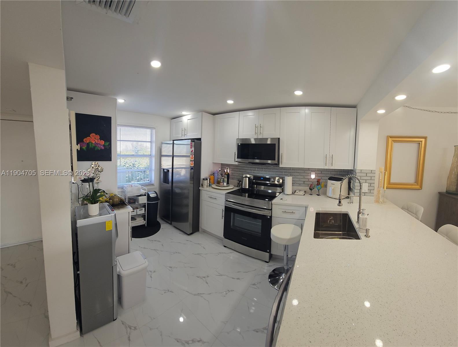 3910 Inverrary Boulevard, Unit 703B Lauderhill, FL 33319 - Photo 22 of 30 a kitchen with a refrigerator and a sink