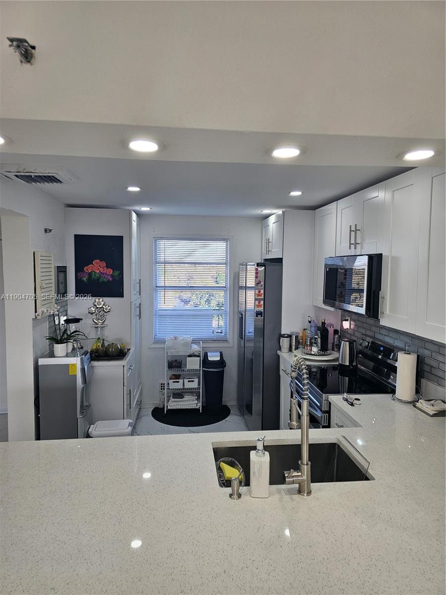 3910 Inverrary Boulevard, Unit 703B Lauderhill, FL 33319 - Photo 24 of 30 a living room with furniture and a flat screen tv