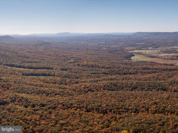 an aerial view of house with yard and mountain view in back