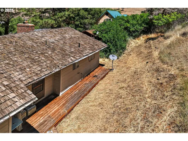 an aerial view of a house with a yard and a large tree