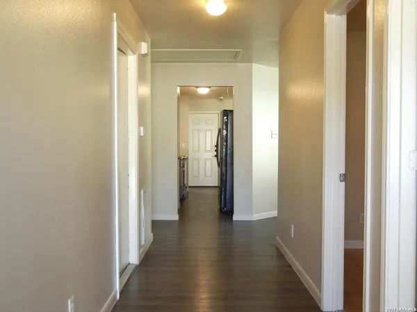 a view of a hallway with wooden floor
