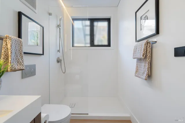 a bathroom with a shower a toilet and a sink