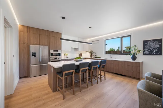 a kitchen with stainless steel appliances wooden floors and wooden cabinets