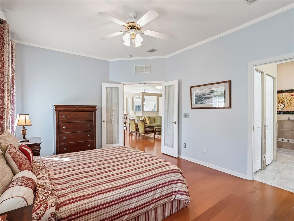 2323 Northwest 55th Avenue Road Ocala, FL 34482 - Photo 17 of 43 a bedroom with a bed and a chandelier