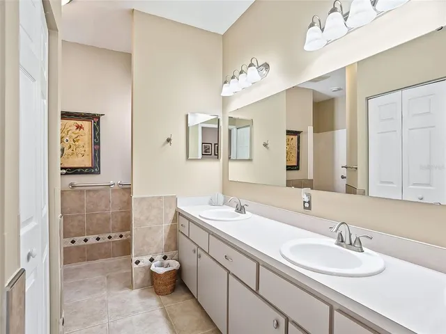 a bathroom with a granite countertop double vanity sink mirror and toilet